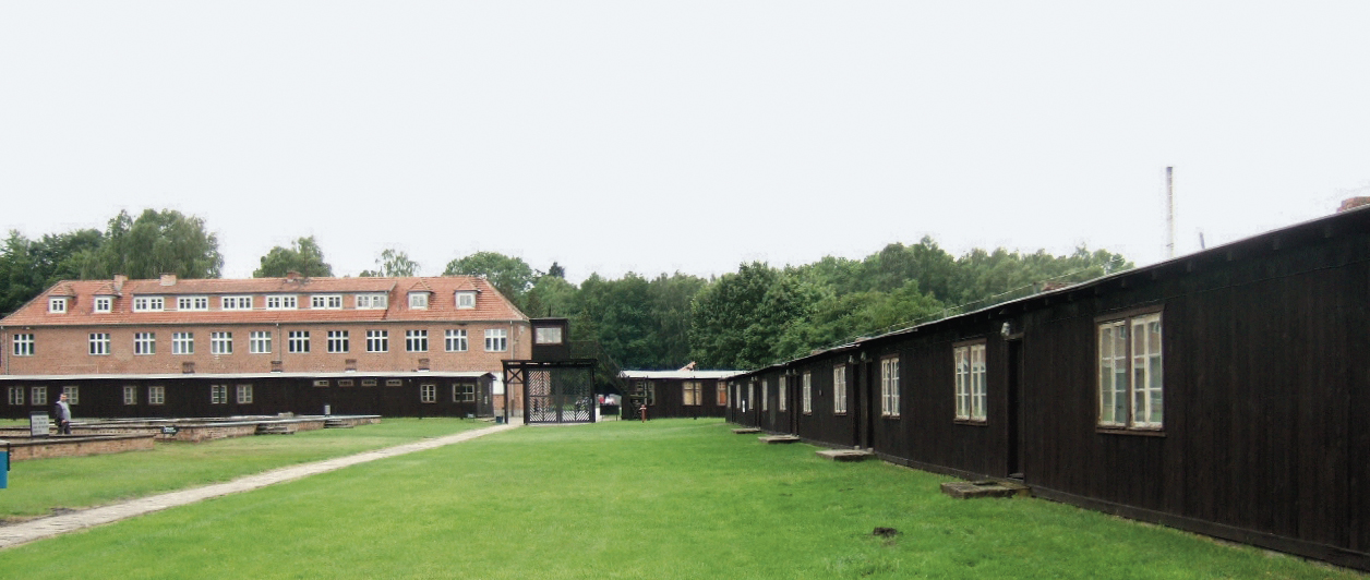 Baracken für die Gefangenen, im Hintergrund die Kommandantur, Foto: © Hans Weingartz, Wikipedia, CC BY-SA 2.0 de