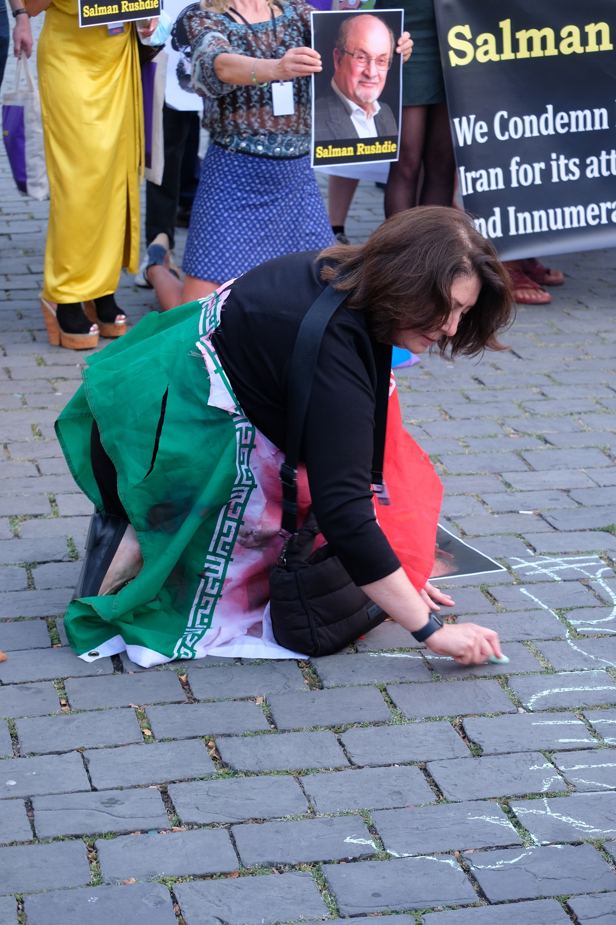 Maryam Namazie schreibt mit Kreide auf den Boden