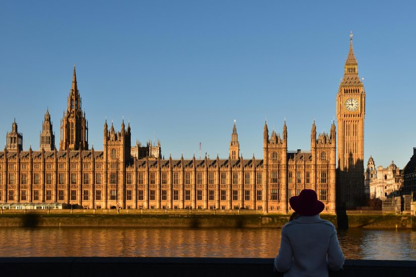 Eine Frau blickt auf das britische Parlamentsgebäude