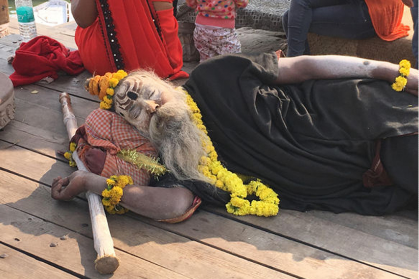Ein mit Asche eingeriebener Aghori schläft am Ufer des Ganges.