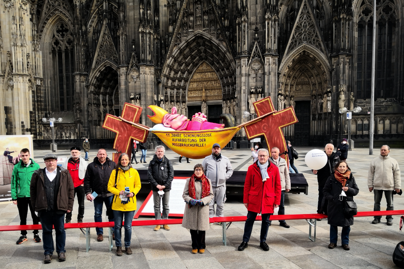 Mitglieder des "Aktionsbündnisses Betroffeneninitiativen" und Aktivistenvor dem Kölner Dom