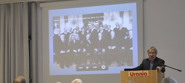 Vortragender Dr. Reinhold Lütgemeier-Davin, im Hintergrund ein Bild der Teilnehmer der deutsch-polnischen Verständigungskundgebung der Liga von 1929 