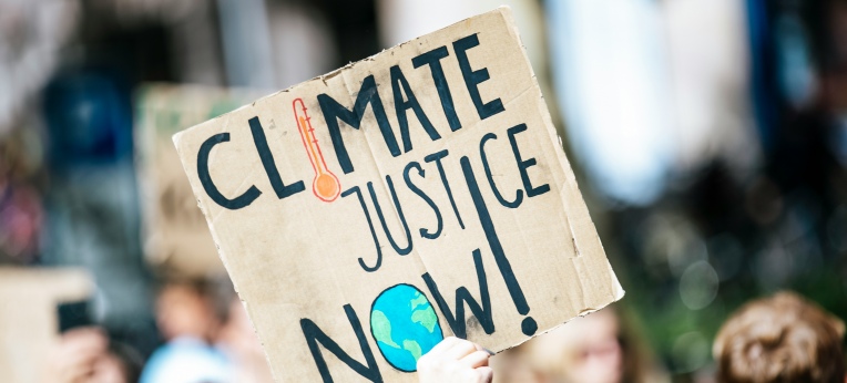 Demoschild fordert Klimagerechtigkeit