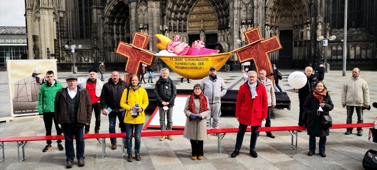 Mitglieder des "Aktionsbündnisses Betroffeneninitiativen" und Aktivistenvor dem Kölner Dom