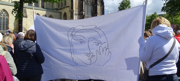 Streikende Katholikinnen mit stilisiertem Porträt einer Frau mit zugeklebtem Mund – dem Symbolbild der Initiative Maria 2.0. 