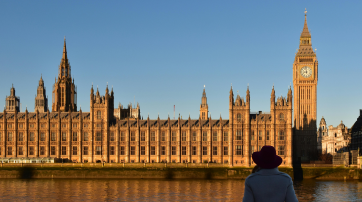 Eine Frau blickt auf das britische Parlamentsgebäude
