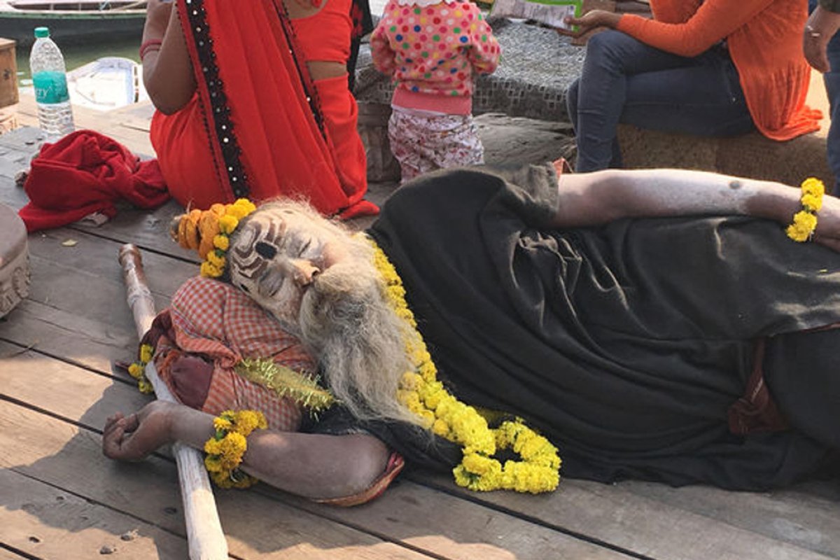 Ein mit Asche eingeriebener Aghori schläft am Ufer des Ganges.