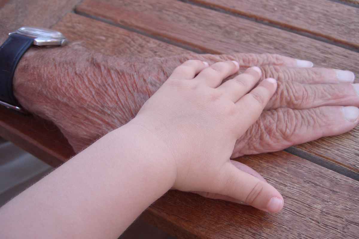 Kinderhand auf alter Hand