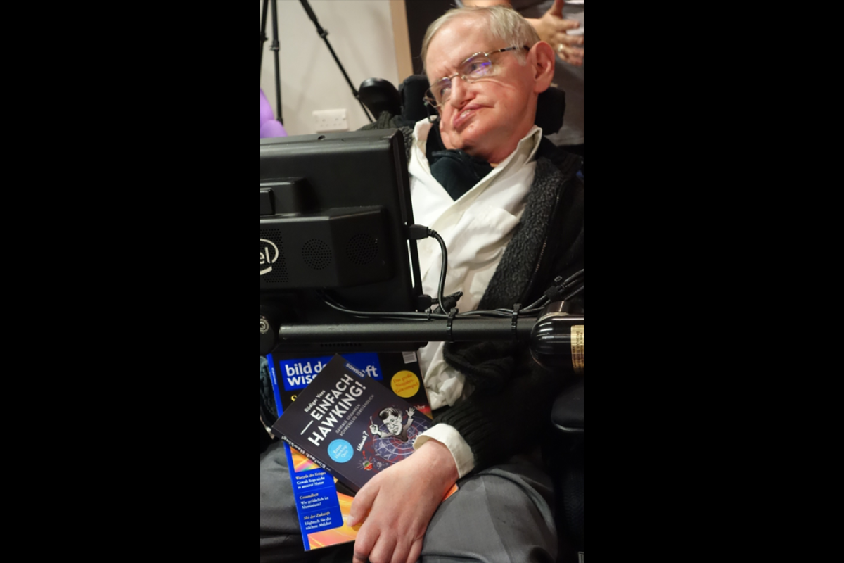 Stephen Hawking mit einem Buch über sein Werk von unserem Autor Rüdiger Vaas.